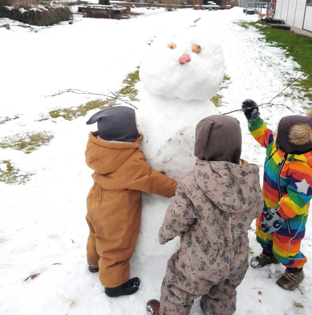 Børn i Tjærbyvejens Vuggestue leger med en snemand